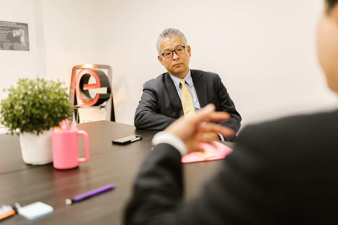Business professionals in a formal meeting discussing ideas in a modern office environment.